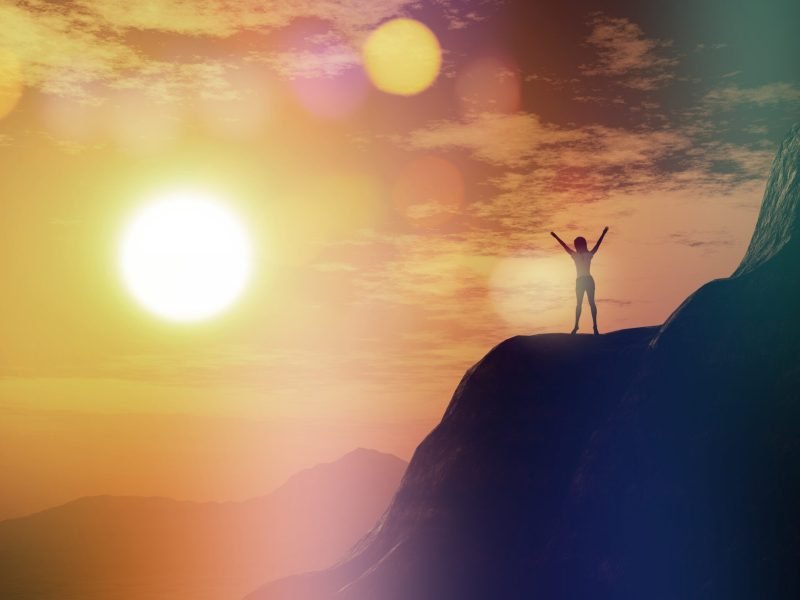 3d-render-female-with-arms-raised-cliff-against-sunset-sky-min